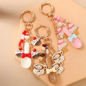 Detail of coffee and cupcake keychains with golden metal spoon and decorative beads