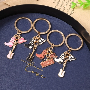 Detail of western cowboy keychains with enamel boots, hats, and guitars on a blue tray