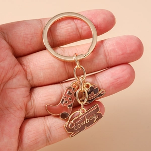 Detail of western cowboy keychain featuring a miniature boot, hat, and cowboy sign