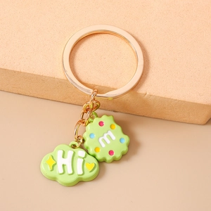 Detailed close-up of a green drip oil keychain charm with stars and Hi lettering