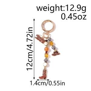Western cowboy keychain with cow print boots and hat charm showing full length measurements