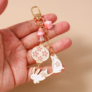 Detail of beaded keychain with white cat, rabbit, and cherry blossom lantern charms