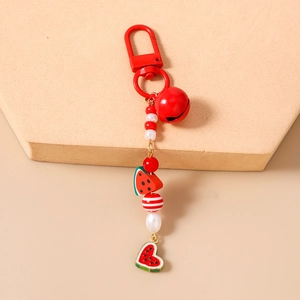 Detailed view of beaded watermelon keychain with red bell and heart-shaped fruit charms