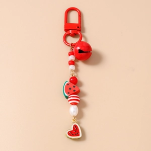 Detail of beaded watermelon keychain with red bell, enamel heart charm and lobster clasp