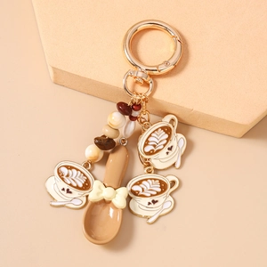 Detailed view of coffee keychain with latte art cups, spoon, and golden metal clasps