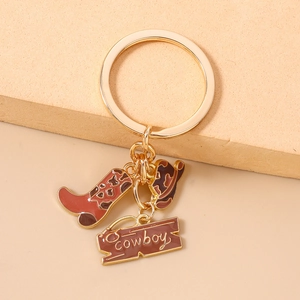 Detailed close-up of Western cowboy boot and hat charms on a golden metal keychain