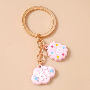 Detail of golden key ring with pink resin cloud HI and letter cookie charms