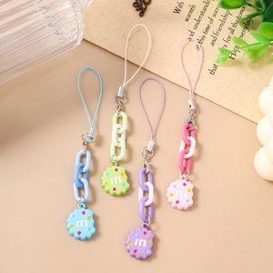 Detailed close-up of macaron-colored biscuit keychains with chunky chains and m-letter charms