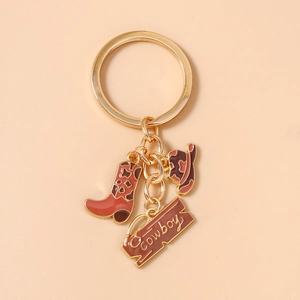 Detail of western cowboy keychain featuring golden ring with enamel boot and hat charms