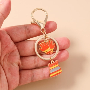 Detail of firefighter keychain with orange safety vest and gloves charms in hand