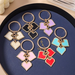Set of pixel heart keychains in six colors arranged in a blue tray for bag accessories