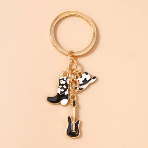 Close-up of cowboy boot, hat and guitar charms on a golden metal keychain ring