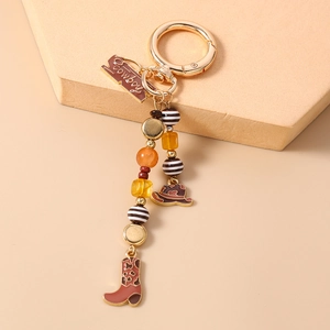 Detail view of Western cowboy keychain with hat and boot charms on golden ring