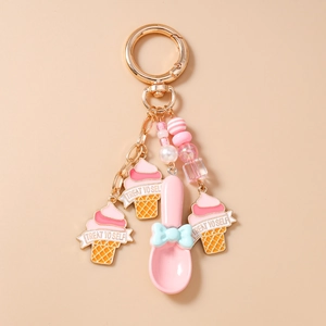 Detail of pink ice cream cone charm with Treat Yo Self text and golden spoon pendant