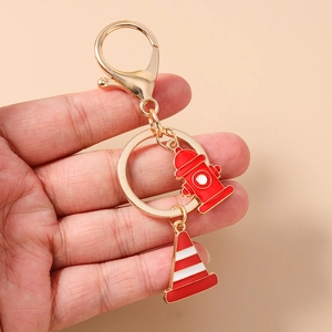 Detail of firefighter keychain with red hydrant and traffic cone on gold alloy ring