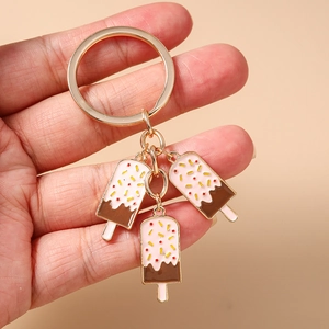 Detailaufnahme von drei rosa Creme- und Schokoladeneis-Anhängern an einem goldene Schlüsselbund
