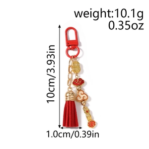 Detail showing red tassel and golden auspicious cloud charm on a beaded keychain