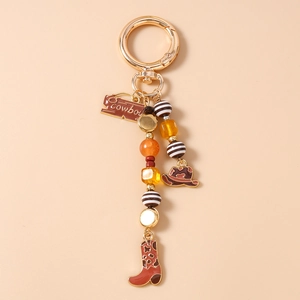 Detail of western cowboy keychain with enamel boots and hat charms on golden beads