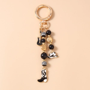 Detail of vintage cowboy guitar keychain with western hat and beaded accessories