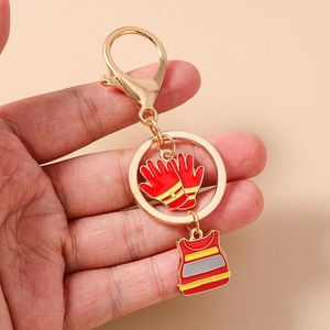 Detail of firefighter keychain with red enamel glove and vest charms on gold ring