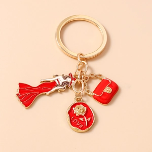 Détail d'un porte-clés doré avec breloque dame en émail rouge et médaillon rose love