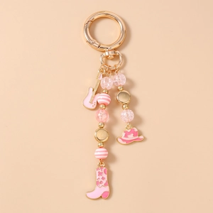 Detail of pink enamel guitar and cowboy boot charms on a beaded keychain with gold clasp