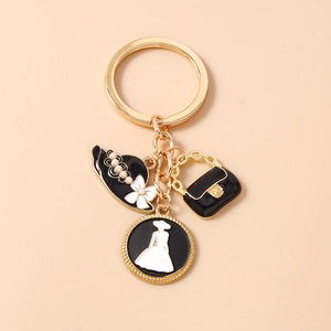 Détail du porte-clés avec chapeau noir, sac à main et pendentifs silhouette élégante