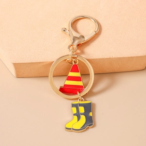 Detail of creative metal keychain featuring traffic cone and safety boot enamel charms
