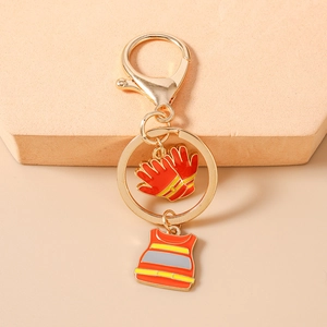 Detail of red firefighter vest and glove charms on a golden lobster clasp keychain