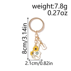 Detail view of gold keychain with white electric guitar and yellow sunflower charms