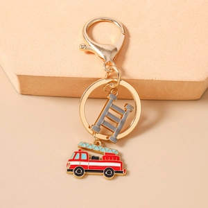 Close-up of a fire truck keychain with a red enamel charm and grey ladder on a beige base