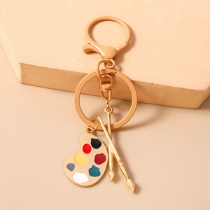 Detailaufnahme von Künstler-Palette und Pinseln Schlüsselanhänger in Champagner-Gold