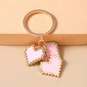 Detail of pink mosaic pixel heart charms on a gold keychain with circular ring