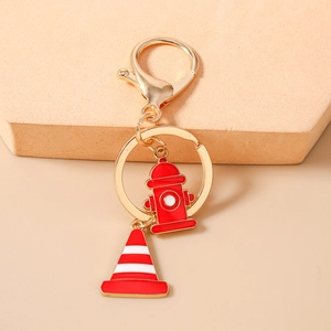 Detail view of gold keychain with creative red fire hydrant and traffic cone pendants