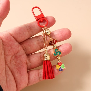 Detailed macro view of a red Chinese tassel keychain with Ping'an Xile enamel pendant