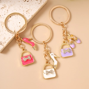 Elegant gold metal keychains featuring high-heel shoes and rhinestone handbag charms