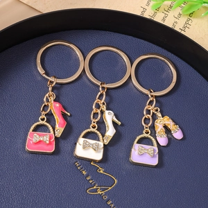 Detailed view of luxury rhinestone handbag and high heel shoe charms on a golden keychain