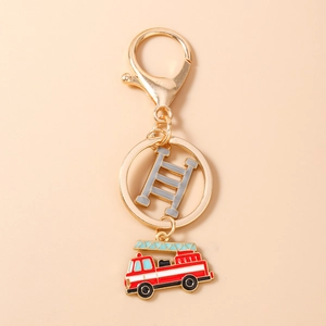 Close-up of golden firefighter keychain with red fire truck and ladder charms
