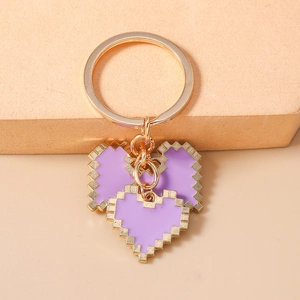 Detail of 8-bit purple mosaic heart keychains with polished gold metal rings