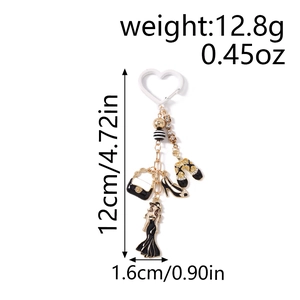 Détail d'un porte-clés mode avec pendentifs robe noire, talons hauts et sac à main