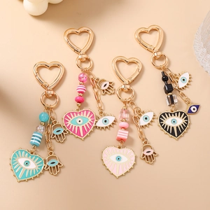 Set of four colorful Evil Eye and Hamsa Hand heart-shaped keychains with gold finish