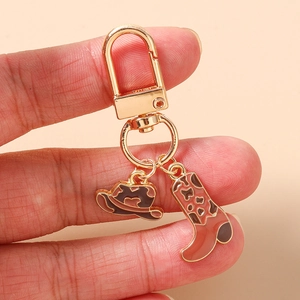 Détail du porte-clés chapeau de cowboy et botte rose avec placage doré et finition émail
