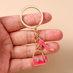 Detailed shot of pink handbag and high heel charms with rhinestones on a gold keychain