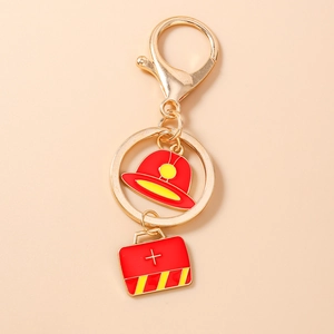 Detail of metal keychain featuring red firefighter helmet and medical kit charms