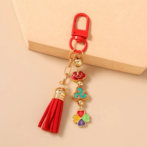 Detail of red tassel keychain with gold auspicious cloud charm and blessing characters