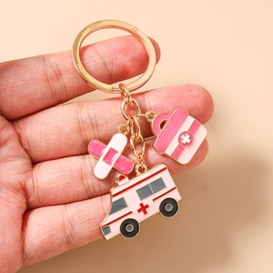 Détail d'un porte-clés médical avec ambulance rose, trousse de secours et pansement