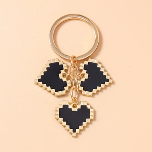 Close-up of gold-tone mosaic pixel heart pendants on a stylish metal keychain link