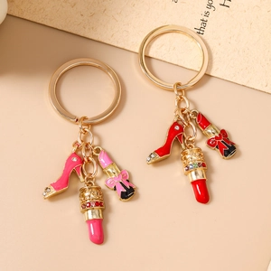 Golden keychain featuring sparkling rhinestone high heels and lipstick charms in pink and red