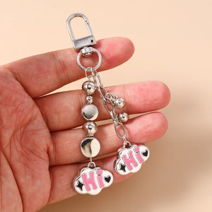 Detailed view of silver beaded keychain with cloud pendants and pink HI lettering