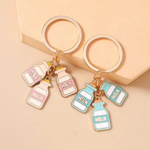 Schattige gouden sleutelhanger set met kleurrijke melkfles hangers in roze en blauw